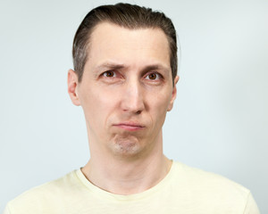 Fototapeta premium Portret zniechęconego mężczyzny, szare tło, seria emocji
