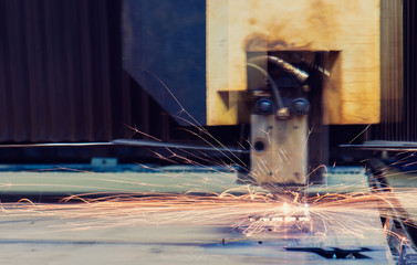Metal cutting in factory. Sparks flying from laser machine.