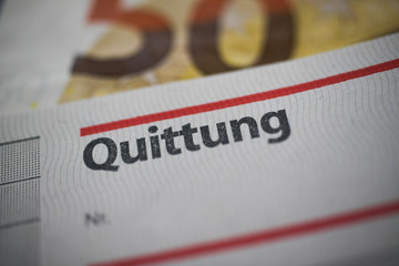 Macro close up of word receipt (german word: Quittung) book, blurred euro 50 paper money bill background