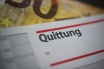 Macro close up of word receipt (german word: Quittung) book, blurred euro 50 paper money bill background