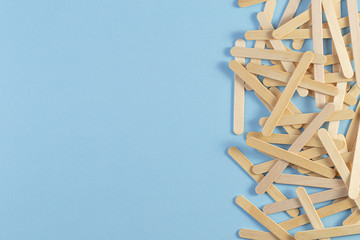 Wooden ice cream stick on blue background. a pile of the wooden sticks. popsicle stick