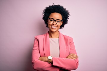 Young beautiful African American afro businesswoman with curly hair wearing pink jacket happy face...