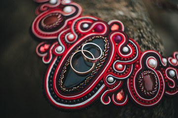 Obraz premium Wedding gold rings close-up on an old, Ukrainian necklace with ancient patterns for pagans, roders. Photography, concept.