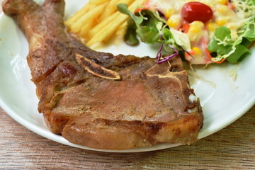 grilled pork chop steak with french fried and salad dressing mayonnaise on plate 