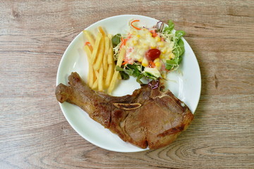 grilled pork chop steak with french fried and salad dressing mayonnaise on plate 