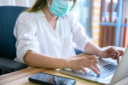 Business woman working from home wearing protective mask. Business woman in quarantine for coronavirus wearing protective mask. Working from home. Cleaning her hands with sanitizer gel.