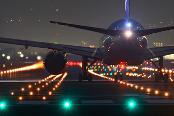 夜の滑走を離陸する旅客機