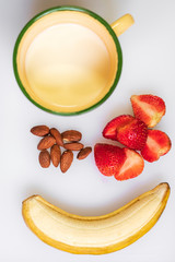 Healthy snack with banana strawberry almond and milk on white background. Healthy and fresh meal concept.