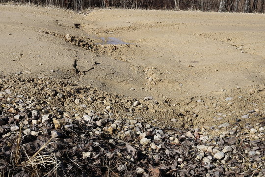 Gravel road, frost heave and dip at center line culvert
