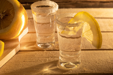 Glass with tequila on a wooden background