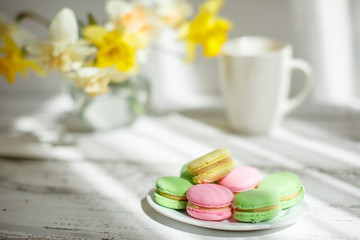 a Cup of tea with macaroons morning Breakfast with a bouquet of flowers in a vase