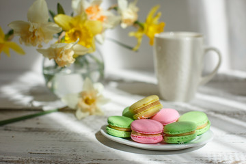 a Cup of tea with macaroons morning Breakfast with a bouquet of flowers in a vase