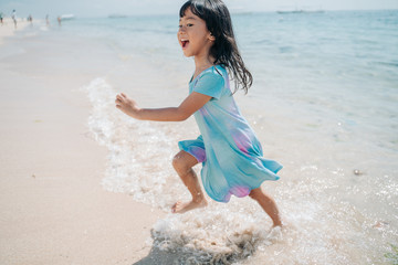 little girls run and laugh while enjoying the beautiful beach
