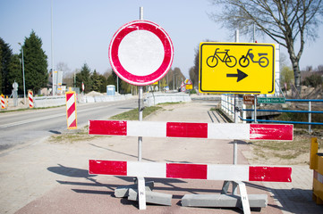 Road closed with barriers and sign for cyclists for roadworks