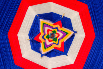 The amulet is made of yarn by binding and weaving into a shape as a symbol of faith in order to...