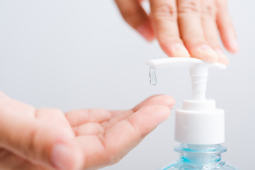 Close up woman applying press dispenser sanitizer alcohol gel pump to hand