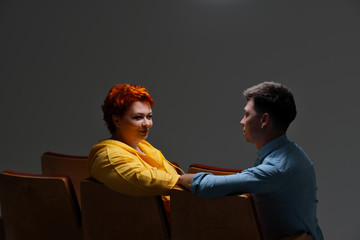 cheerful couple holding hands and sitting on chairs