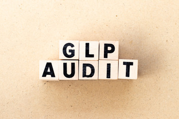 Letter block in word GLP (Abbreviation of Good laboratory practice) audit on wood background
