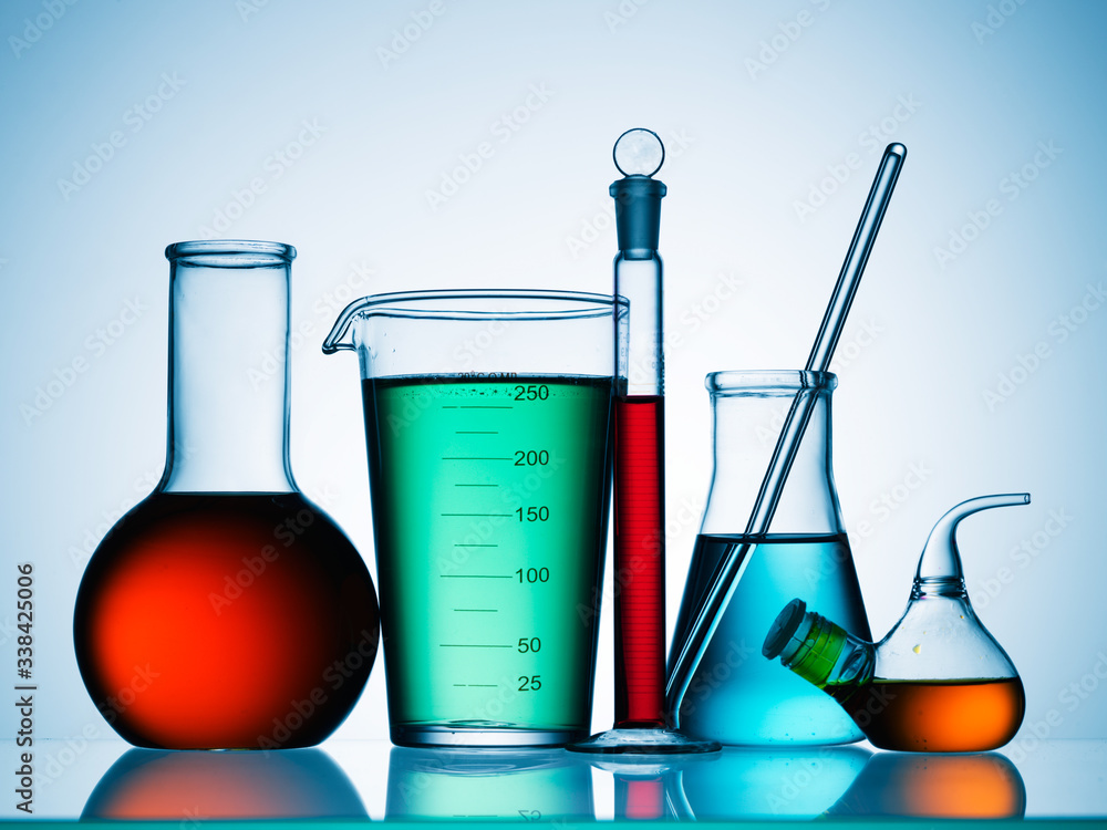 Wall mural different laboratory glassware with color liquid and with reflection