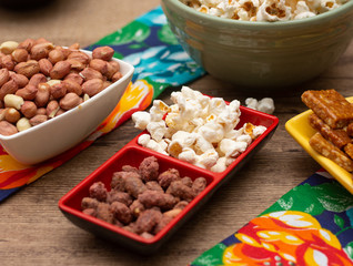 several  bowls  with  popcorn  and  peanuts on the  table