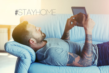 man lying on sofa with digital tablet pc at home