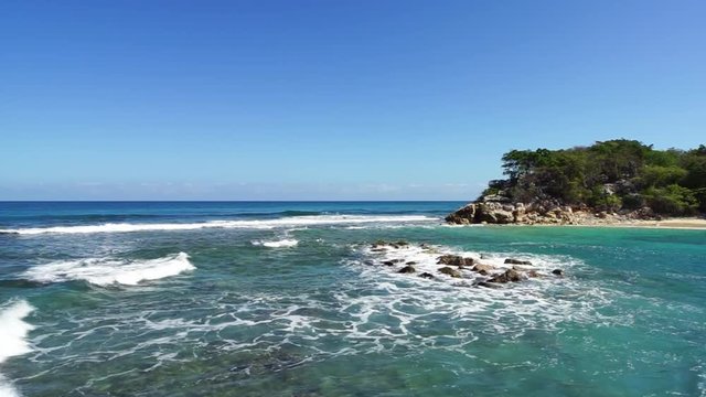 Waves hitting the rocks on a sunny day on Labadee Island in Haiti.