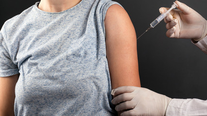 doctor makes injection of vaccine from covid-19. forced implantation of a nano chip under the guise...