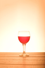 a small glass of red wine on a wooden table