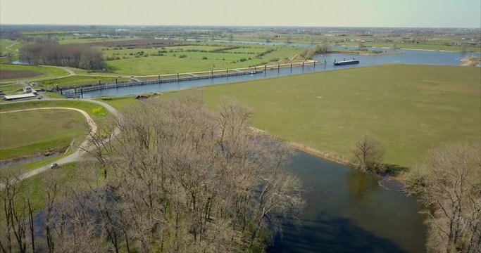 Aerial view of canal and road on the flat landscape of the Netherlands.