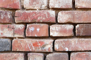 Red brick wall with cracks and scratches. Old background texture. Vintage house facade.