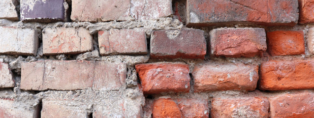 Red brick wall with cracks and scratches. Аbstract background texture.