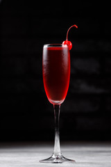 austere classic dark cherry cocktail with red cherry on a dark background. cocktail bar menu concept.