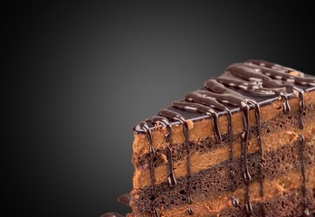 Delicious chocolate cake with chocolate cream on dark background