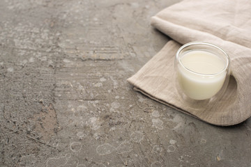 High angle view of glass of homemade yogurt on beige cloth on grey background