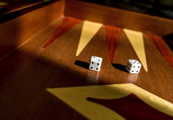 Die/Dice on Backgammon board game - dark mahagoni wood, shadows - casino