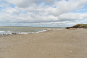 Fototapeta na wymiar Piriac sur Mer en Loire Atlantique en Bretagne magnifique rivage de sable doré plage où viennent mourir les vagues et côte de rochers plongeant dans l'océan