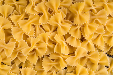 Top view closeup macro on italian raw uncooked farfalle pasta, horizontal format