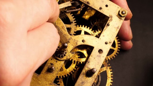 The watchmaker assembling the old clockwork. Brass watch wheels closeup.