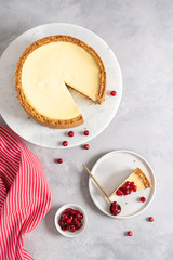 Obraz na płótnie Canvas New York cheesecake or classic cheesecake with fresh berries on white plate, wooden table background and copy space for text