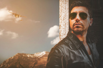 Man in sunglasses. Mountain background with two fighter planes.