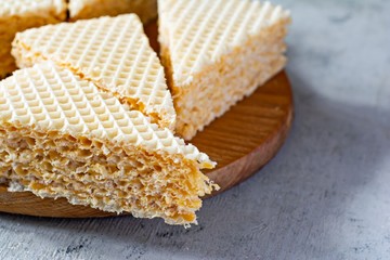 Waffle cake made of crispy waffle cakes with boiled condensed milk on a gray background. Quick sweet dessert.