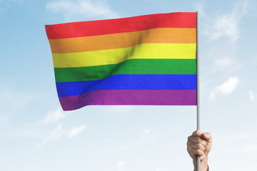 LGBT flag in a raised hand.