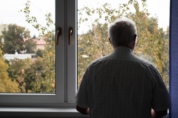 sad senior man stand alone stay at home inside closeup depressed coronavirus isolation