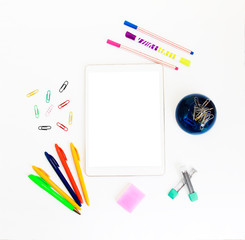 white electronic tablet and stationery, pens, paper clips, pencils and writing paper