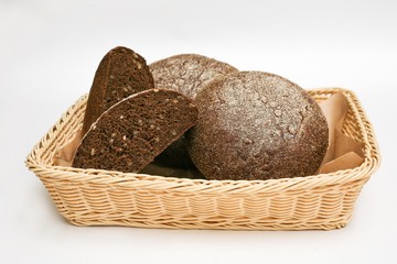 black bread with sunflower seeds in a basket white background