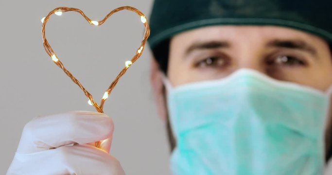 Sorriso di un medico Italiano con simbolo del cuore in mano.