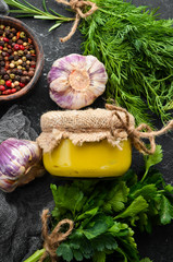 Mustard in a glass jar on a black stone background. Top view.