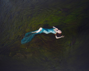 beautiful red-haired girl bathes in a stormy stream, hot summer