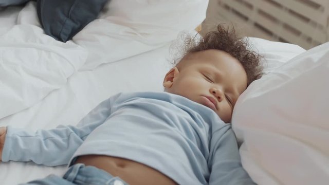 Close up of African sweet child lying in bed and sleeping