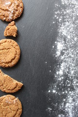 homemade oatmeal cookies on a dark gray background dusted with powdered sugar